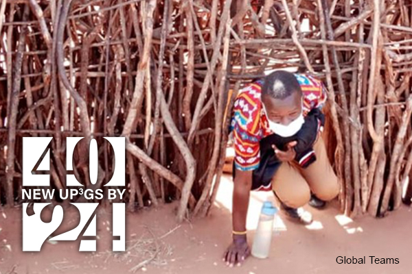 Dodoth man goes through a small opening in a thatched wall