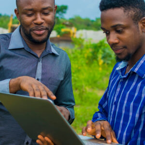 two men using a laptop